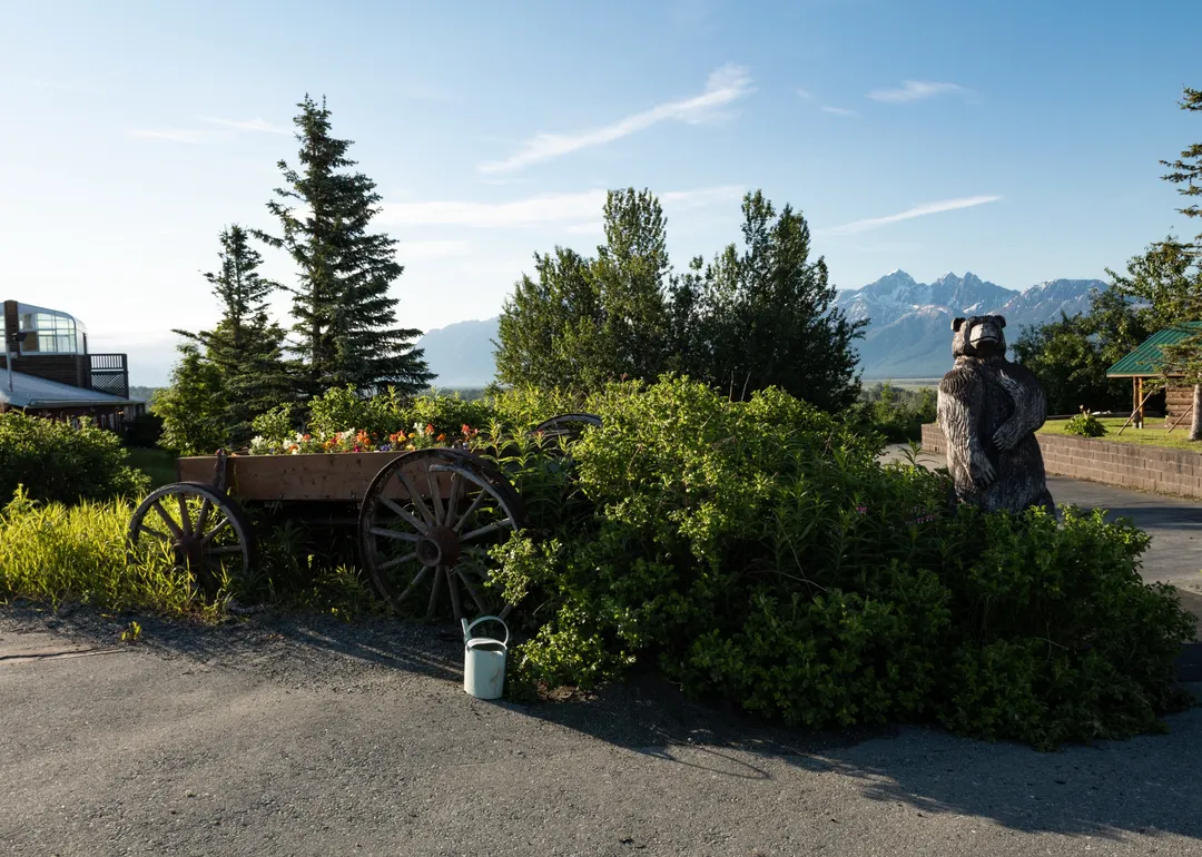 wooden bear statue mountains background